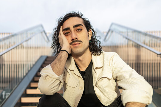 Contemplative man sitting on stairs with relaxed expression