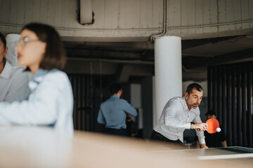Multiracial business workers engage in a lively table tennis game during their break at the office,...