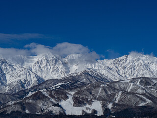 Obraz premium 北アルプスの山並みとスキー場 遠景 長野県白馬村