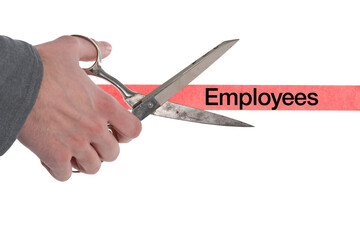 Isolated male hand with scissors cutting through red tape with employees written on it