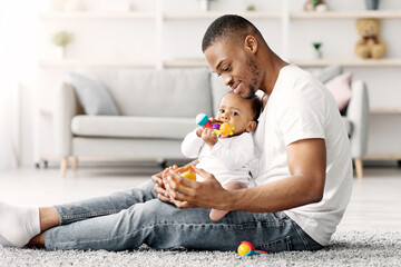 Paternity Time. Loving Young African American Father Playing With His Little Infant Baby At Home,...