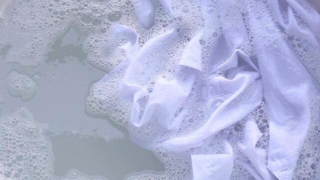 Shirt soak in powder detergent water dissolution, washing  cloth. Laundry concept
