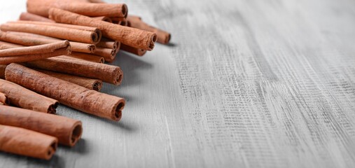 Many cinnamon sticks on wooden background with space for text, closeup