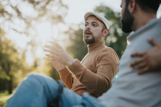 Two friends engage in a deep, meaningful conversation while sitting outdoors in a sunlit park. The scene captures a moment of connection and tranquility amidst a natural, serene backdrop.