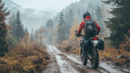 Motorcyclist braving cold overcast weather on mountainous dirt roads embodying extreme sport and active lifestyle in enduro off road touring