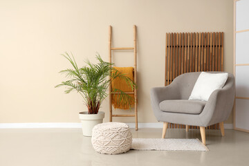 Interior of living room with wooden ladder, armchair and palm tree