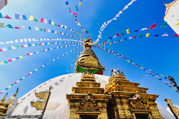Buddhist prayer flags flutter in the breeze at the Swayambhunath Mahachaitya complex dedicated to...