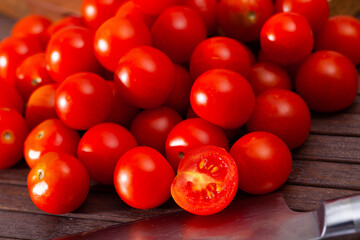 Fresh cherry tomatoes ready for cooking on natural wooden background