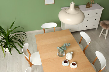 Interior of modern dining room with teapot and cups on table