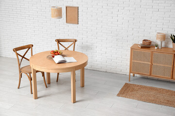 Table with apples and book in interior of dining room