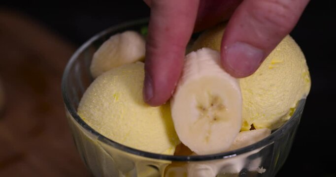 ice cream with banana flavor, creamy ice cream with yellow banana slices in a glass cup