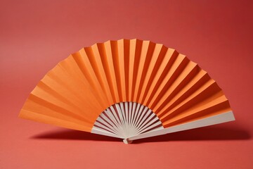 there is a orange paper fan on a red background