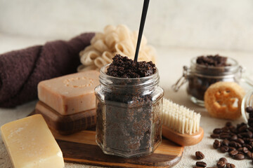 Composition with jar of coffee body scrub, wooden cutting board and soap bars on light background