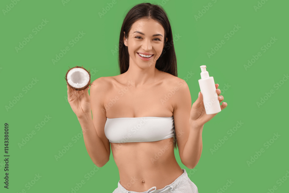 Wall mural Beautiful young happy woman with coconut and bottle of cosmetic product on green background