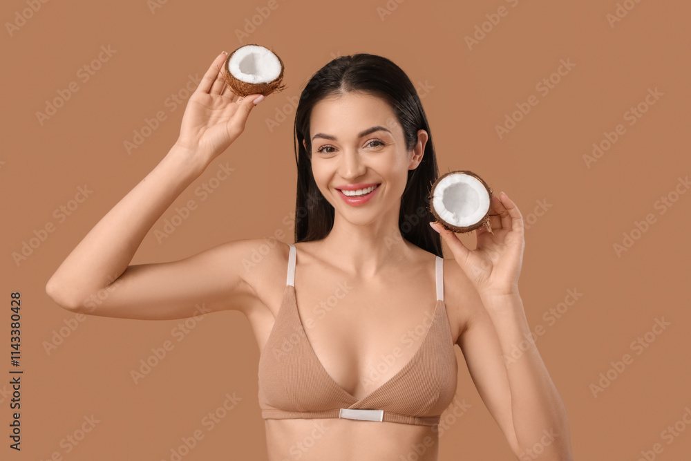 Wall mural Beautiful young happy woman with coconut on brown background