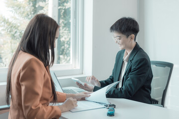 Car insurance salesman introduces customer to table with small car and car keys, sales concept, accident insurance, car dealership