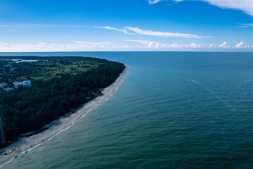 Aerial view captures the beauty of Weizhou Island in Beihai showing sandy shores and lush greenery under a clear blue sky