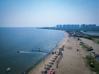 Scenic view of Bohai Bay at Dongdaihe beach with summer activities and coastal skyline