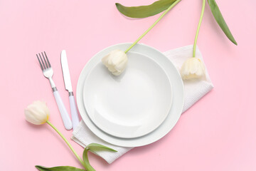 Stylish table setting with beautiful tulip flowers on pink background
