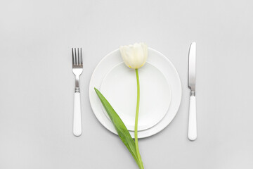 Stylish table setting with beautiful tulip flower on lilac background