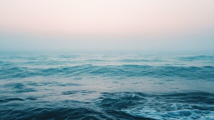 Obraz premium Gentle Waves Under Soft Morning Light with Misty Horizon View