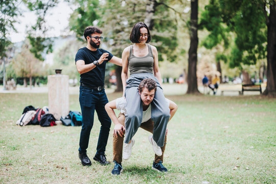 A group of students actively participate in a creative outdoor sports class, guided by their instructor in a park setting. The scene captures a lively and collaborative atmosphere.