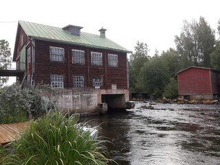 Old wooden hydroelectric power plant on a river in Finland