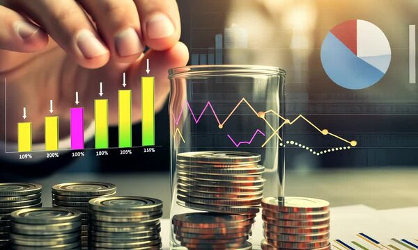 Hand placing coins in a glass jar with overlaid financial graphs.