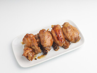 Grilled chicken wings on white rectangular plate