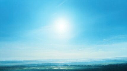 Obraz premium A bright blue sky with no clouds, the sun shining warmly over a tranquil landscape. The calmness of the scene brings a sense of peace, as if the world is paused in a quiet moment.