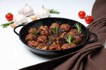 Meatballs in black bowls with spices on a white background