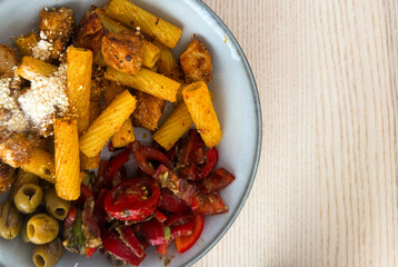 Delicious pasta dish with grilled chicken and fresh vegetables served on a round plate