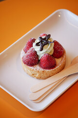 A Delicious Strawberry Cream Tart beautifully presented on a White Plate