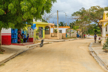 A dirt road with a few houses and a bicycle