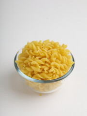 Fusilli pasta in a bowl on white background
