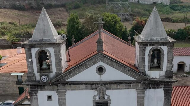 Aerial of Igreja Paroquial de Santo Est&ecirc;v&atilde;o in Vilela, Paredes, Portugal, with flying birds