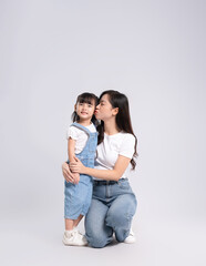 Naklejka premium Full body image of Asian mother and daughter posing on white background