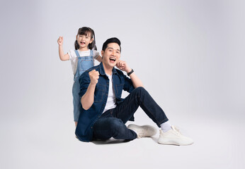 Full body image of Asian father and daughter posing on white background © STOCK88PHOTOGRAPHER