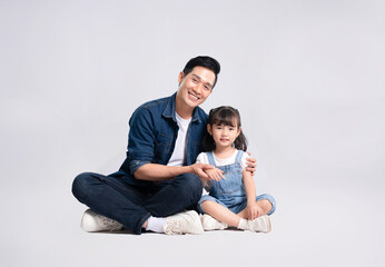 Full body image of Asian father and daughter posing on white background