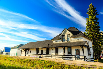 Obraz premium A large white house with a black roof sits on a grassy field