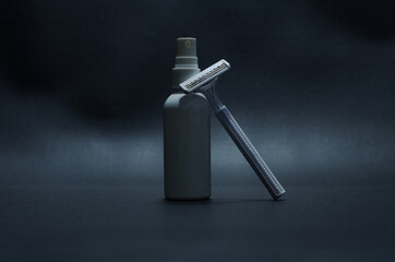 A Razor and Spray Bottle on Minimalistic Dark Background