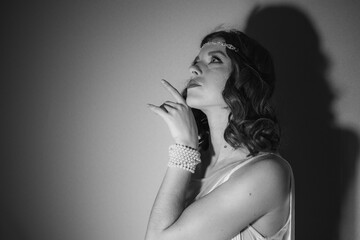 Black and white photo of a beautiful girl with hair and makeup in retro style

