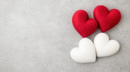 Obraz premium Colorful fabric hearts on a concrete surface symbolize love and affection, perfect for romantic occasions or decor.