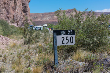 National Route 25 sign, kilometer 250, with rocky mountains in the background
