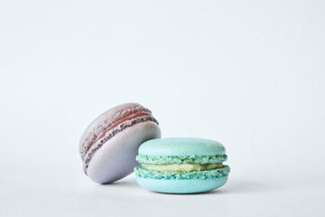 Two colorful French Macarons, cakes with different flavors, mint, apple, currant flavor. dessert, macaroons aquamarine, green, purple color. Copy space for text