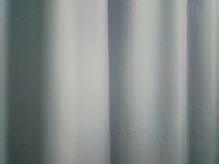 Fototapeta premium the texture of the light blue curtains is neatly installed, giving a minimalist and calm impression to the room.