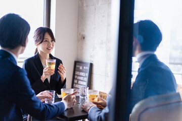 お酒を飲みながら話すビジネスパーソン