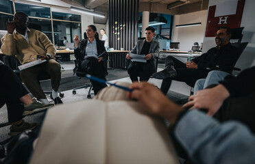 A diverse group of professionals sit in a modern office, actively engaging in a business meeting. They appear focused and enthusiastic, sharing ideas and taking notes. Teamwork and collaboration are