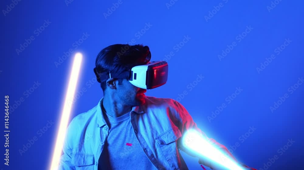 Poster gamer playing game while holding glowing sword and wearing vr glasses. attractive male model excited