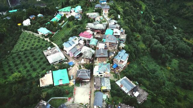 Beautiful drone shot of a village near kasol in Parvati valley with old rustic houses at the foothills of Himalayas in Himachal Pradesh, India